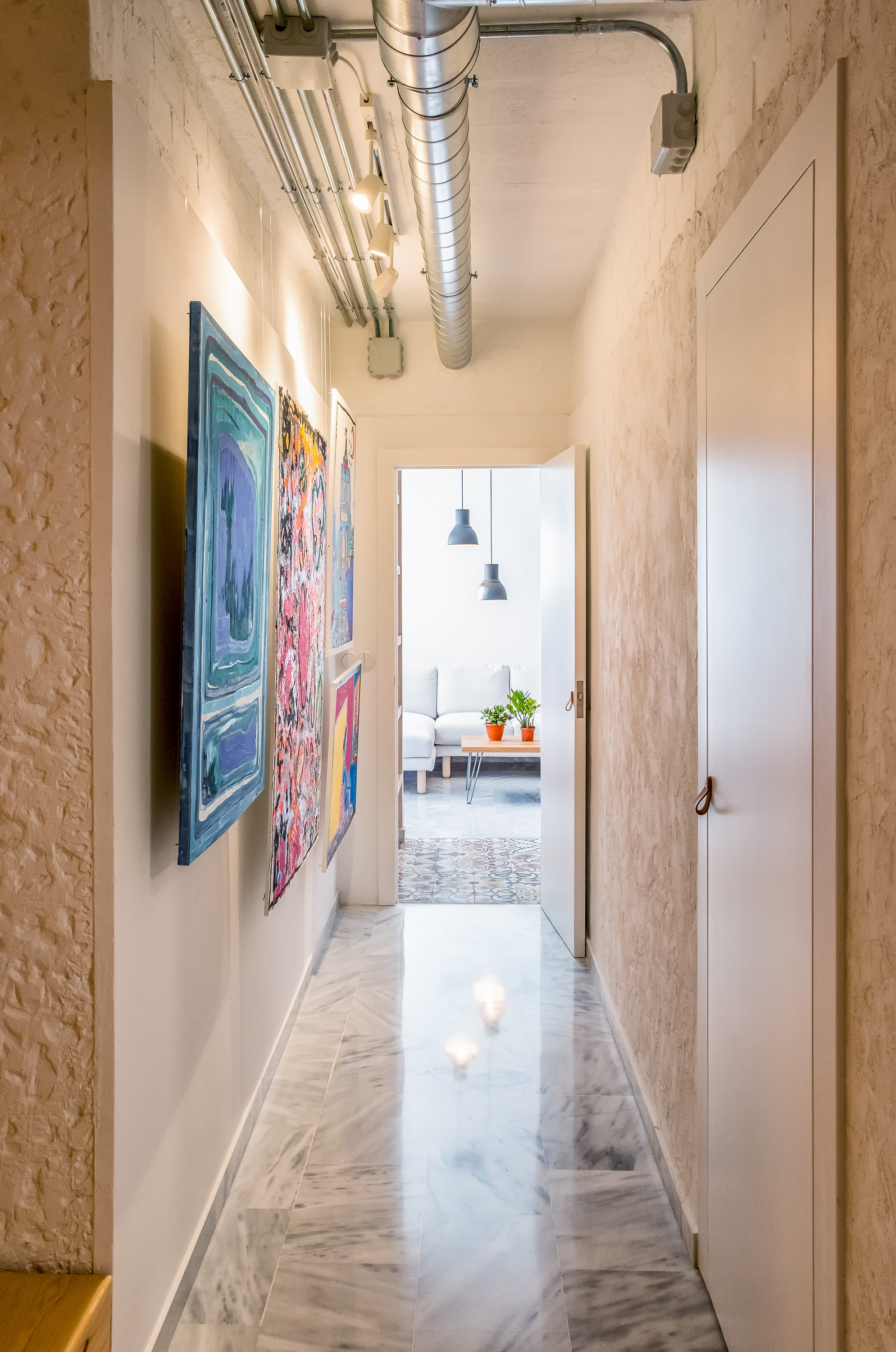 Distribuidor convertido en una galería doméstica donde arquitectura, luz y pintura acompañan el recorrido entre los diferentes espacios de la casa.