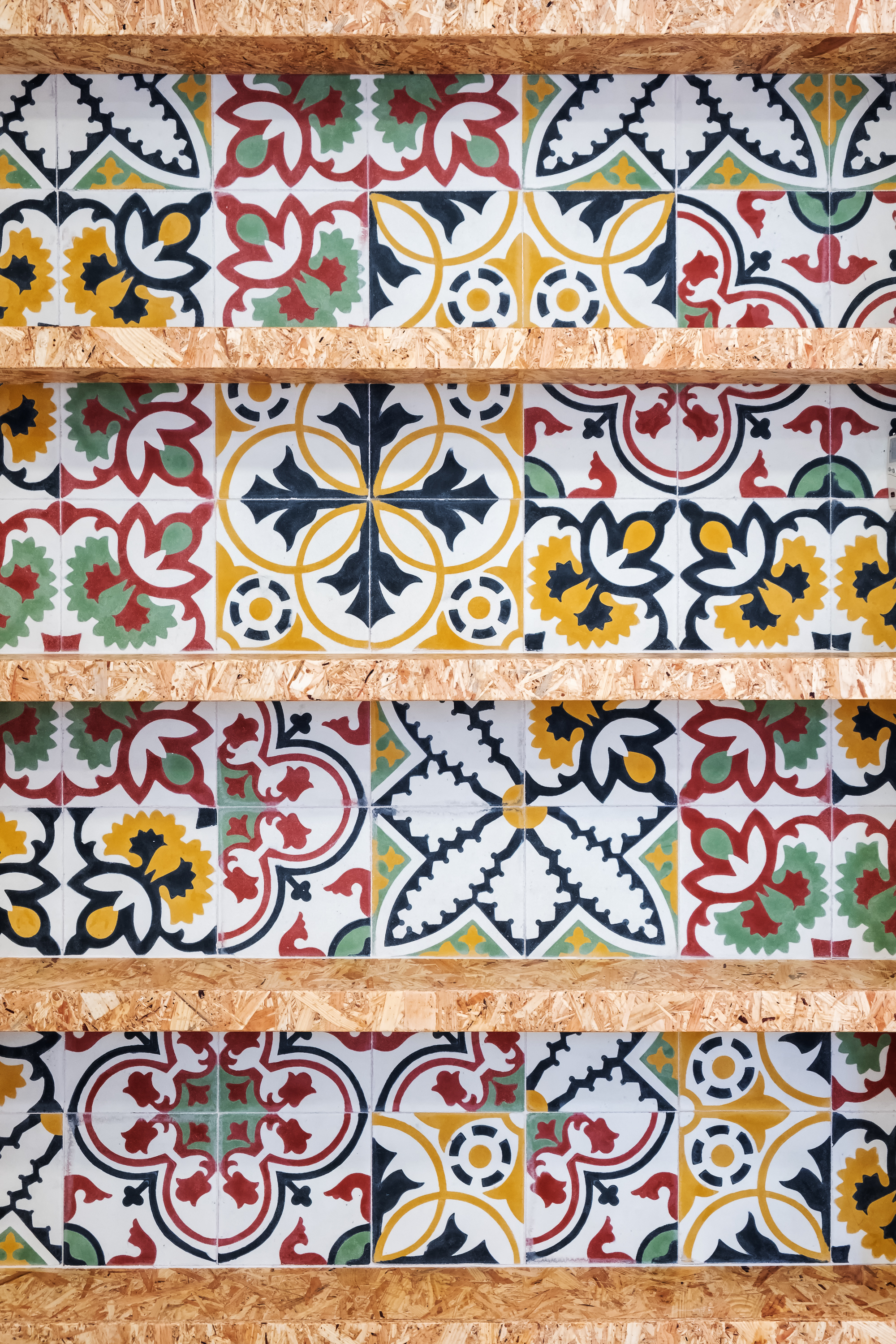 Detalle de las baldosas hidráulicas diseñadas para Casa Atelier junto a estanterías de tablero OSB, materiales inspirados en el universo de la pintura.