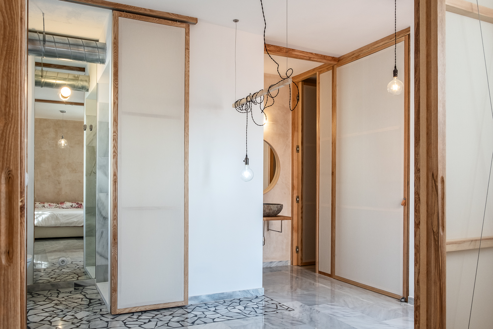 Panel corredero abierto que conecta el vestidor con el dormitorio, permitiendo una configuración flexible del espacio.
