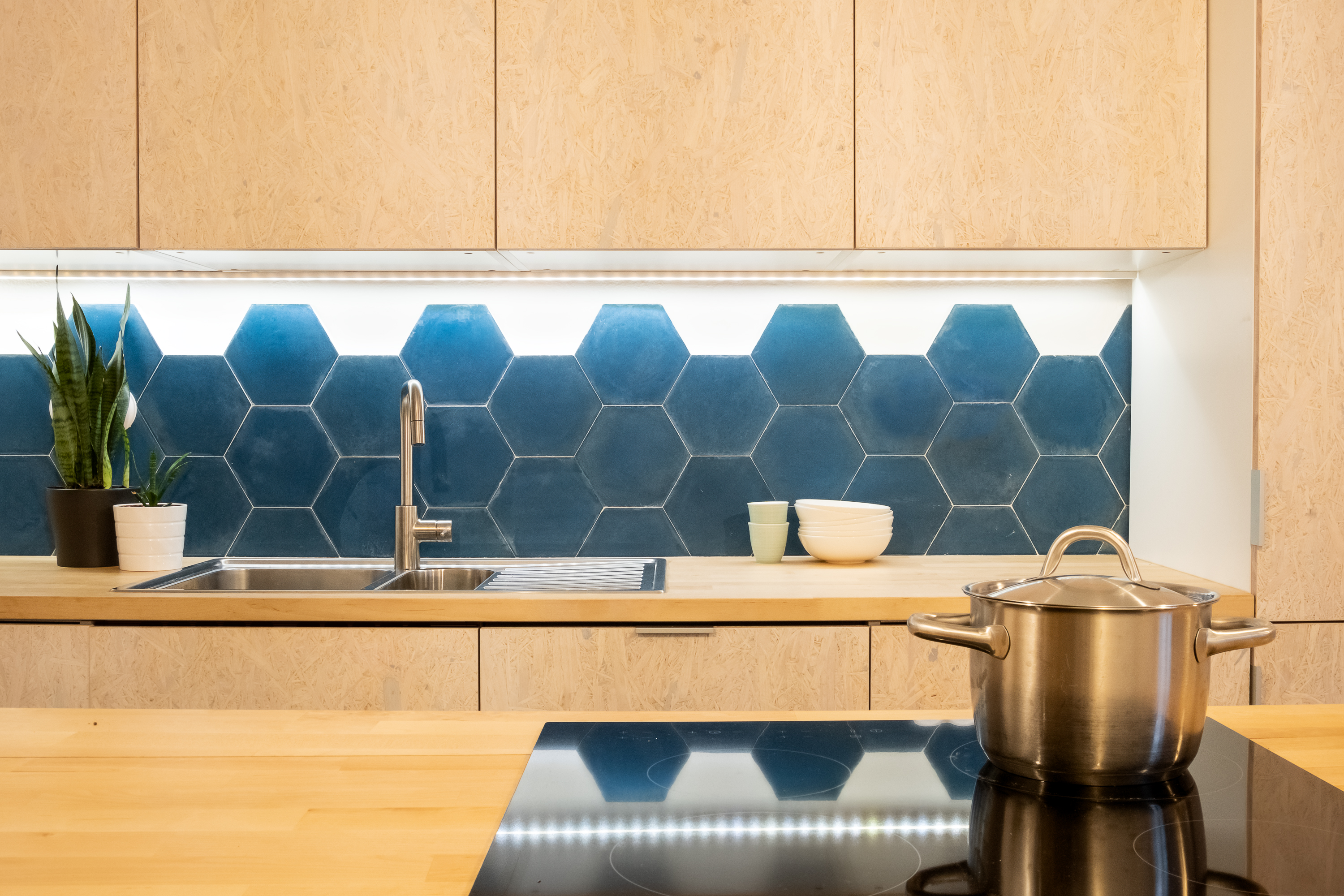 Cocina de plywood con encimera de madera y revestimiento cerámico azul en Homeping