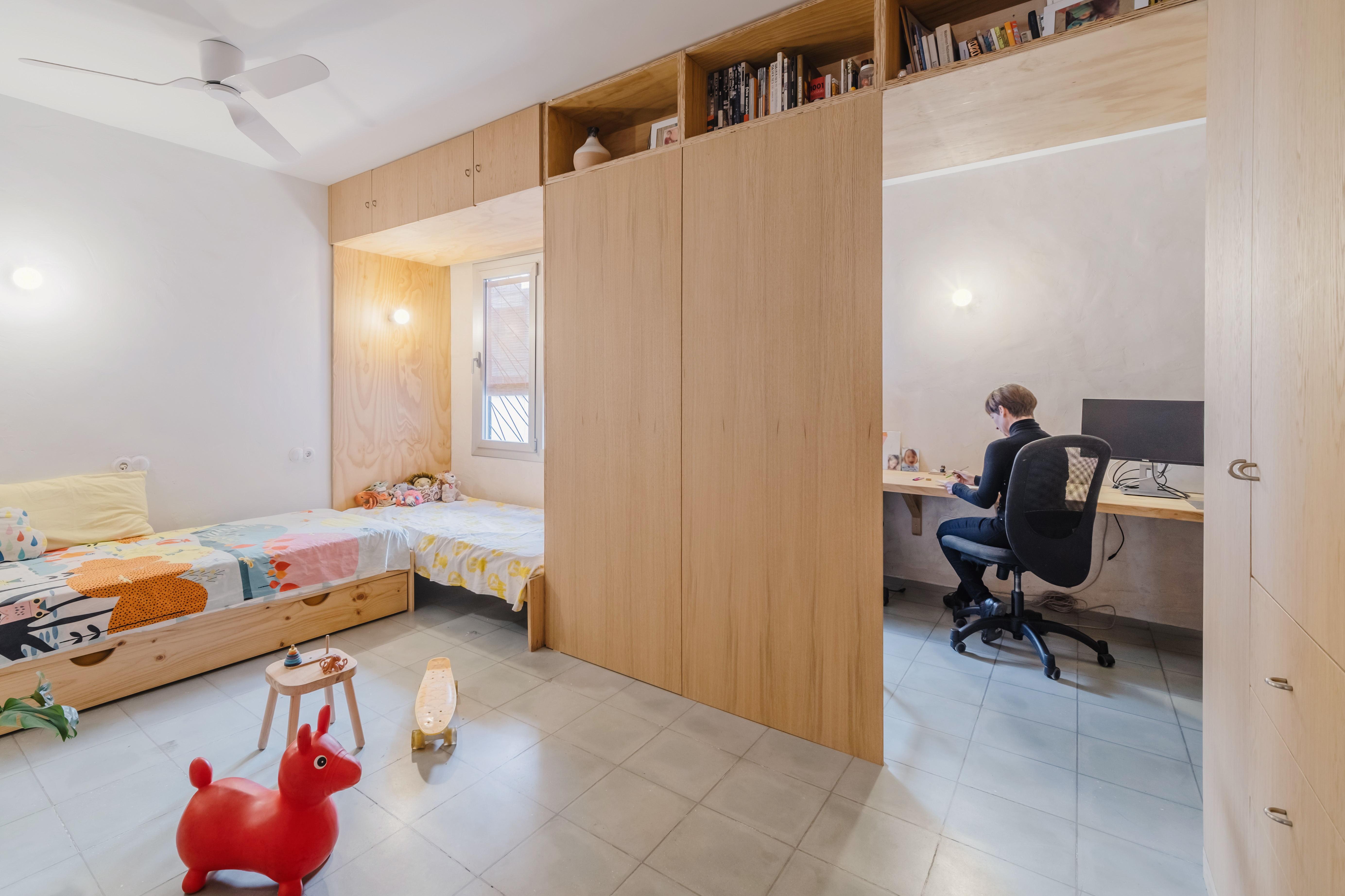 Dormitorio con mobiliario integrado y materiales naturales.